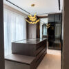 Luxury Walk In Closet Design | Dark Wood Island with Glass Top & Accent Chandelier