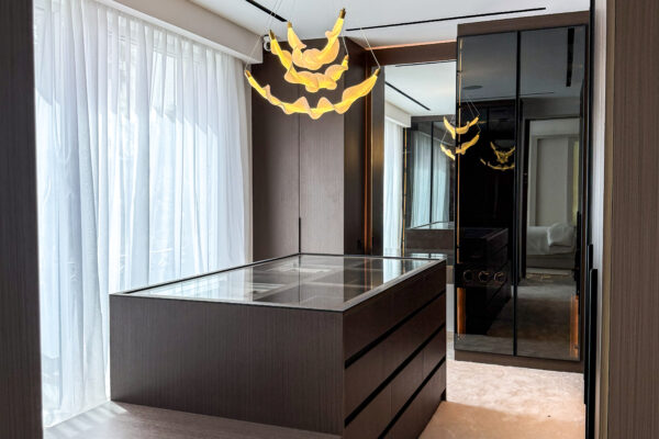 Luxury Walk In Closet Design | Dark Wood Island with Glass Top & Accent Chandelier